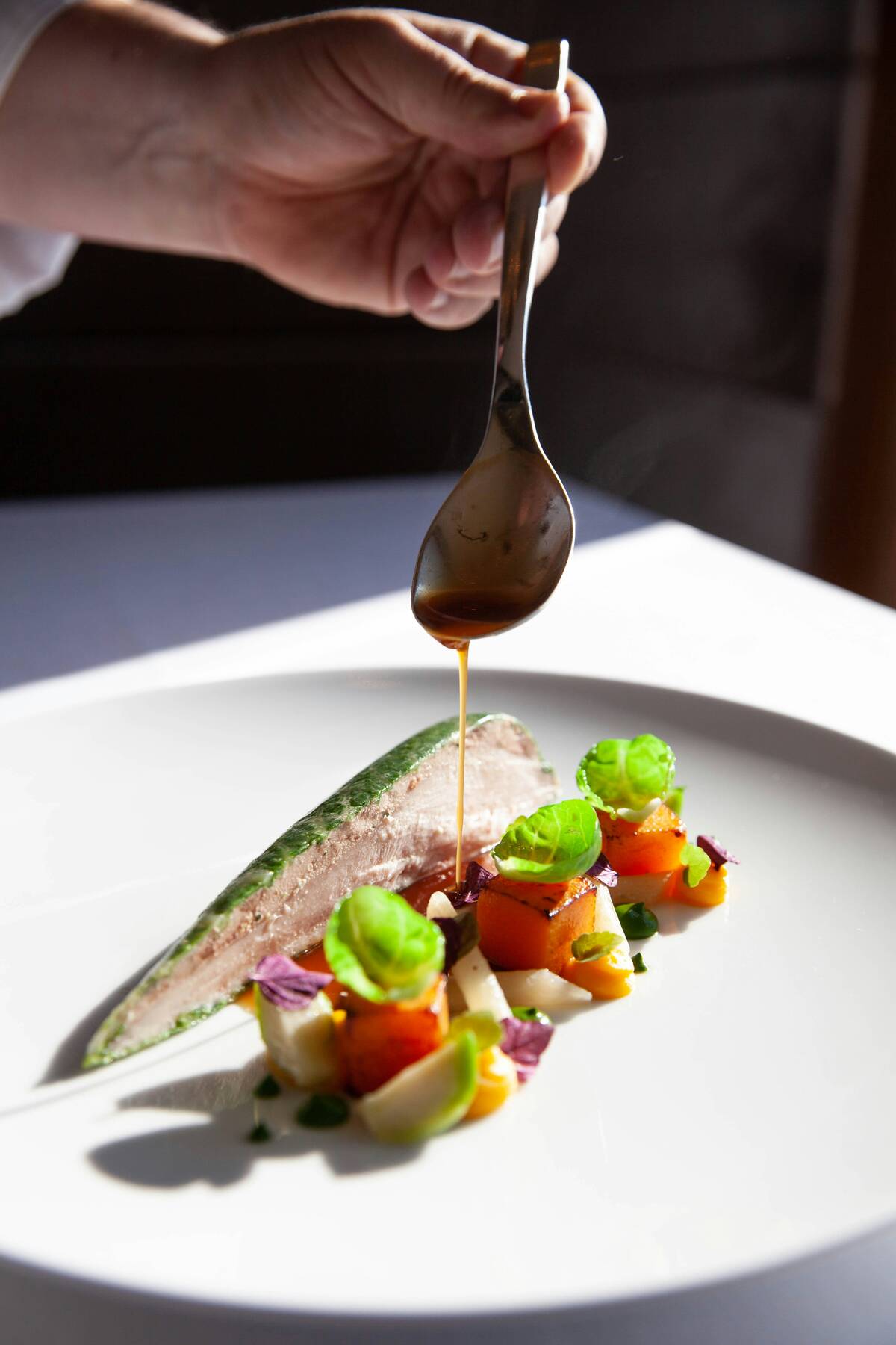 Fish course being dressed with sauce