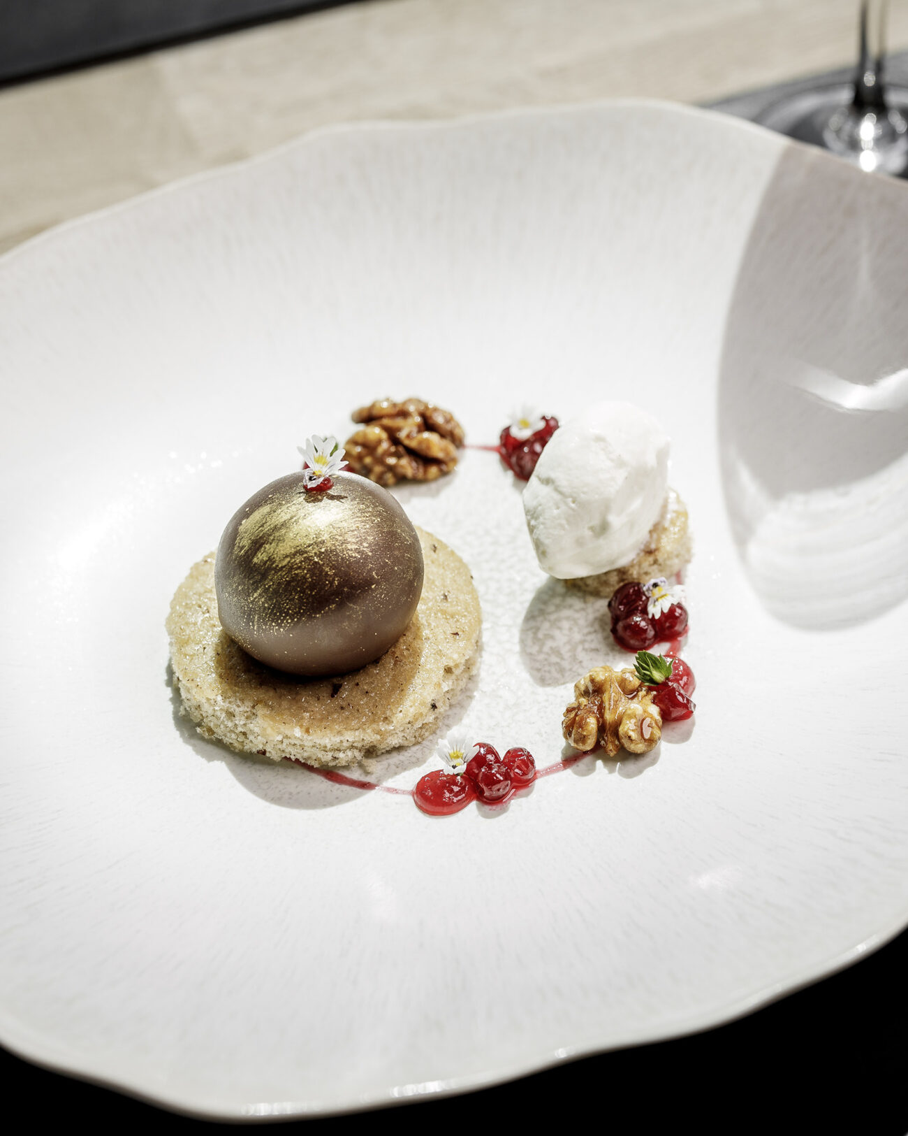 Dessert mit Schokoladenkugel, Walnüssen und Preiselbeeren
