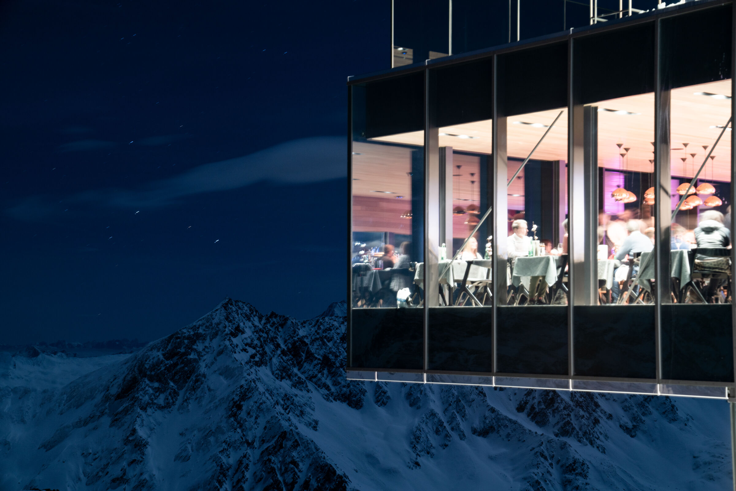 The illuminated ice Q at night above the snowy Ötztal Alps